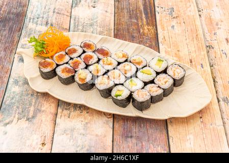 tray with sushi maki assorted fish, meat and vegetables garnished with Japanese vinegar and white rice wrapped in nori seaweed Stock Photo