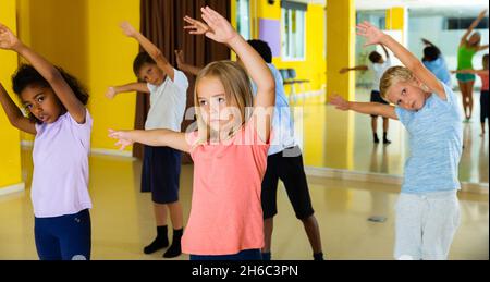 Portrait of smiling children practicing sport dance in modern dance hall Stock Photo