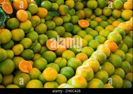 Many green tangerines on the counter in the market. Stock Photo