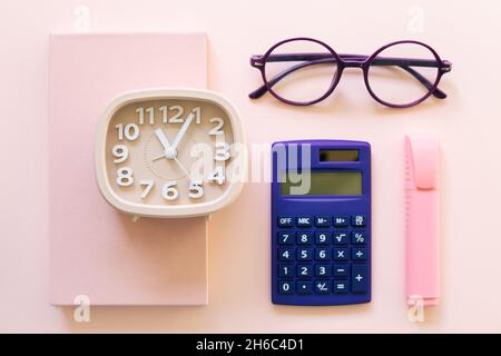 Notebook, clock, calculator, glasses, pen on pink background. workspace. flat lay, top view Stock Photo