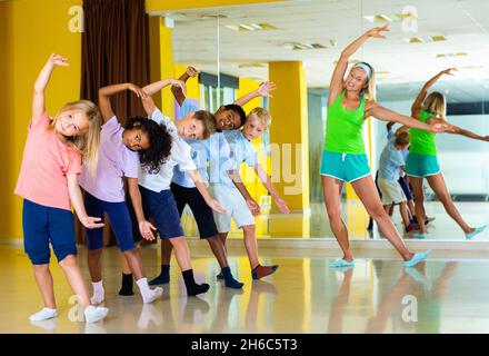 Preteen dancers practicing dance routine with female choreograph Stock Photo