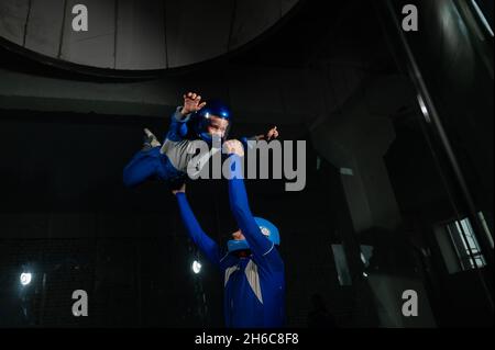 A man teaches a boy to fly in a wind tunnel. Stock Photo