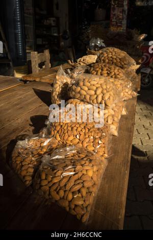Packed almond nuts for sale on the wooden table in retail shop Stock Photo