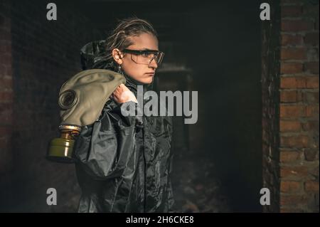 Beautiful military girl. Portrait of a woman with a gas mask in a destroyed building. Post-apocalypse concept Stock Photo