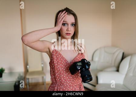 Freelance photographer woman with camera at home office editing photos on computer Stock Photo