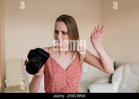 Freelance photographer woman with camera at home office editing photos on computer Stock Photo