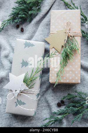 Christmas presents on gray knitted textile background. Kraft paper gift boxes, Christmas  and Happy New Year composition. Flat lay style, top view Stock Photo