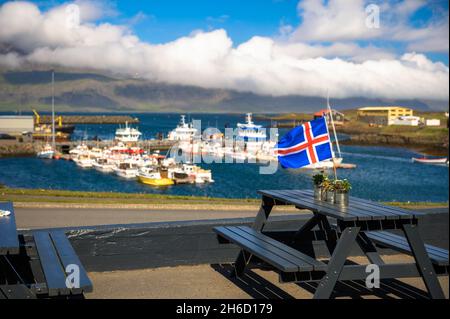 Flag of Iceland placed on a restaurant table with a harbor in the background Stock Photo