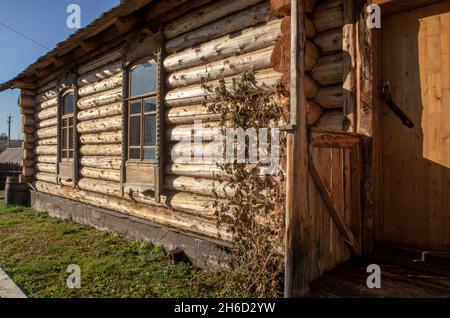 A fragment of a wooden hut made of round logs in a village in Siberia Stock Photo