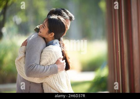 dating young asian couple hugging embracing outdoors in park Stock Photo