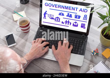 Government aid concept shown on a laptop used by a man Stock Photo