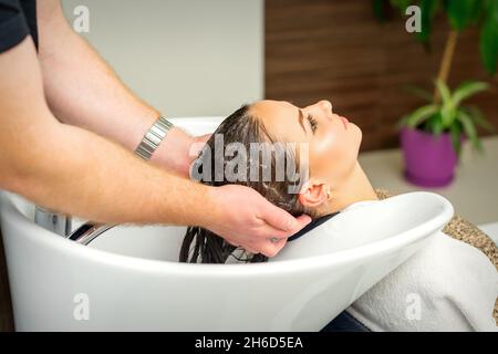 Beautiful caucasian woman washing hair in a beauty salon Stock Photo