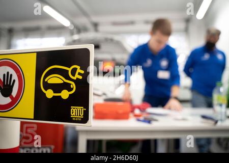 PRODUCTION - 12 November 2021, Hessen, Frankfurt/Main: A warning sign stands in the workshop during work on an electric vehicle. The best from each federal state take part in the national competition. Photo: Frank Rumpenhorst/dpa Stock Photo