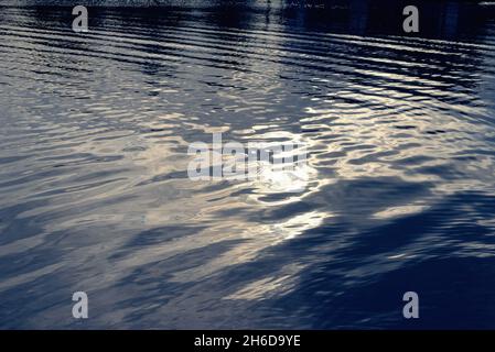 Soft abstract patterns and shapes caused by sunlight reflecting  on the surface of a river Stock Photo
