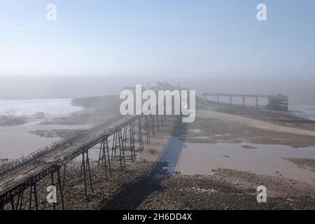 Birnbeck Pier, Birnbeck Island, Weston-Super-Mare, Somerset, 2018. General view of the derelict pier shrouded in mist at low tide, from the east. Stock Photo