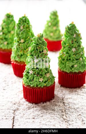 Christmas tree cupcakes on wooden table Stock Photo