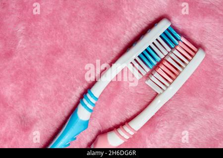 Two toothbrushes on a pink fluffy towel Stock Photo