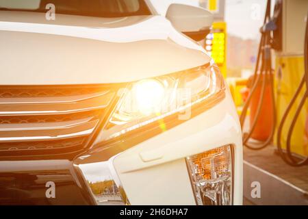 modern car at a gas station. white SUV pouring gasoline Stock Photo