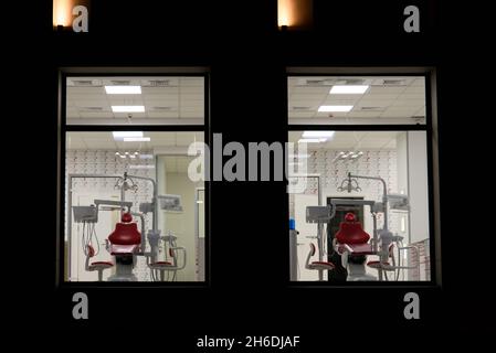 new dental office. night dentistry. red dental chair, view through the window Stock Photo