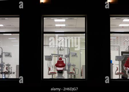 new dental office. night dentistry. red dental chair, view through the window Stock Photo