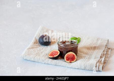 organic fig homemade confiture made by family recipe in a small jar on grey concrete background, side view, copy space Stock Photo