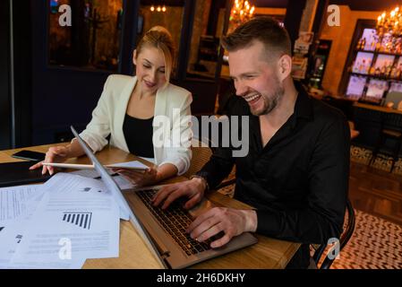 .shot of two businesspeople using a digital tablet and a laptop during their meeting inside a coffee shop Stock Photo