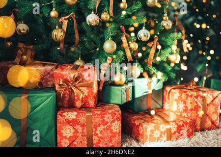 Many gift boxes standing under decorated Christmas tree Stock Photo