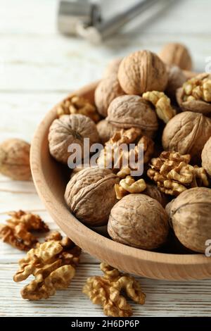 Nutcracker and bowl of walnuts on white wooden background Stock Photo