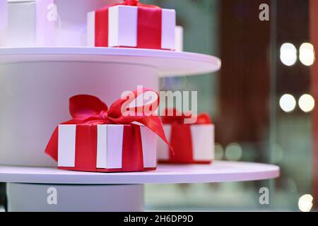 Gift boxes in window store on blurred lights background. Concept of christmas sale and presents Stock Photo