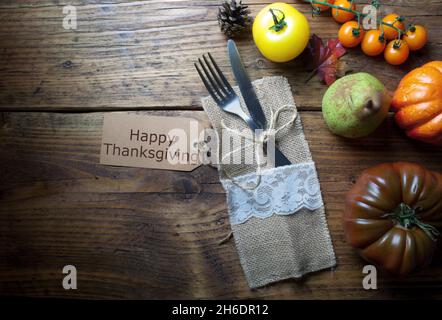 Thanksgiving greeting card attached to fork and knife on wooden table Stock Photo