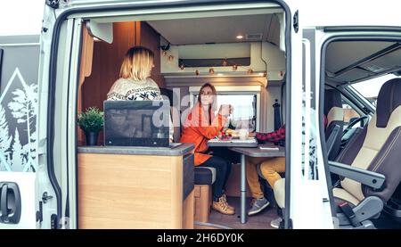 Friends having breakfast in a camper van in the morning Stock Photo