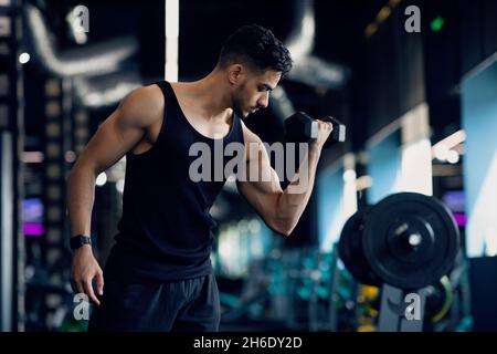 Handsome Muscular Middle Eastern Man Training With Dumbbells In Modern Gym Stock Photo