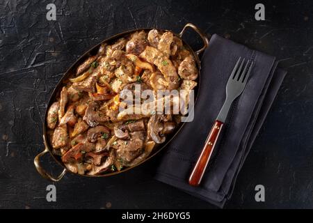 Beef stroganoff, mushroom and meat ragout with cream sauce, overhead shot on a black background Stock Photo