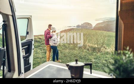 Unrecognizable couple traveling in camper van looking coastline landscape Stock Photo