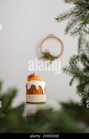 Traditional Christmas cake with decorated tangerines, dried apricots, berries. Christmas wreath on the background. High quality photo Stock Photo