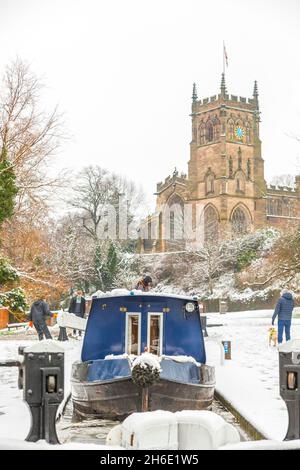 Uk narrowboat travelling through the lock at Kidderminster on the Staffordshire and Worcestershire canal in winter snow. Stock Photo