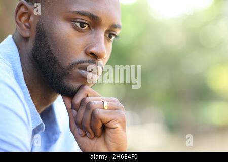 Clos eup portrait of a worried husband with black skin thinking looking away Stock Photo