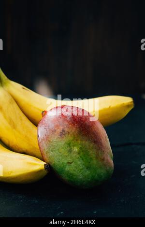 Mango and banana fruits on the black background Stock Photo