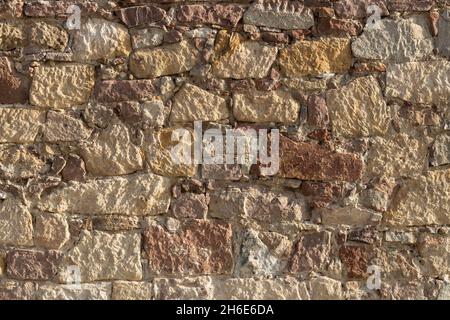 Historic stone wall. Texture of a stone wall. Old castle stone wall texture background. Stock Photo