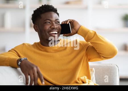 Cheerful african american guy having phone conversation with friend Stock Photo