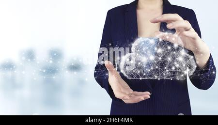 Modern cloud technology. Integrated digital web. Two hand holding virtual holographic cloud icon with light blurred background. Cloud computing techno Stock Photo