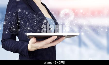 FAQ frequently asked questions concept. Hand hold white tablet with digital hologram question mark sign on light blurred background. Business support Stock Photo