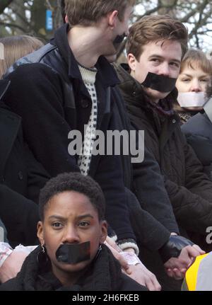 Students tape their hands and mouths in London today ahead of tomorrow