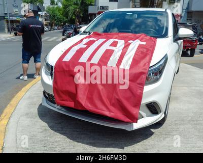 Buenos Aires, Argentina - Nov 7, 2021 - A red fabric flag with the Fiat brand covering the hood of a white Argo. Expo Warnes 2021. Copyspace