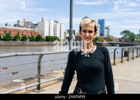 A Portrait of a senior woman walking along the harbor with a bridge in the background Stock Photo