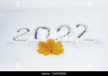 Number 2022 is symbol of next New Year, written on freshly fallen snow that lies on windshield car Stock Photo