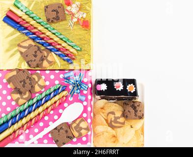 Decorative Colorful Glittering Candles Placed On Gift Boxes. Crispy Wafers Chips, Cookies and Chocolate Biscuits For Merry Christmas And Happy New Yea Stock Photo