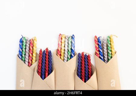 Collection Of Multi Colored Decorative Glittering Golden Yellow, Red, Blue And Green Candles Packed In Brown Craft Papers. Isolated On White Backgroun Stock Photo