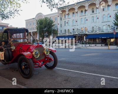 Red antique car parked across the street from The Adelphi Hotel on Broadway in Saratoga Springs, New York, USA, 2021 © Katharine Andriotis Stock Photo