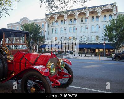 Red antique car parked across the street from The Adelphi Hotel on Broadway in Saratoga Springs, New York, USA, 2021 © Katharine Andriotis Stock Photo